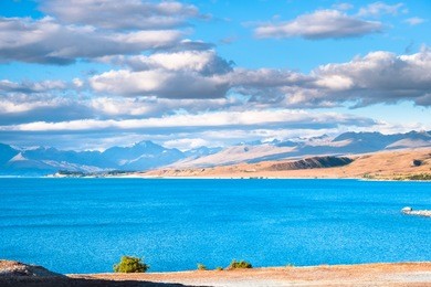 beautiful scene of the yellow grassland mt cook and lake tekapo before sunset.
