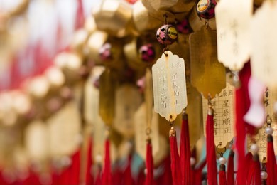 golden buddhist prosperity tag at wong tai sin temple people wish and hang them on red ropes for praying in hong kong. non-english in an image means wishing for good luck in coming year.