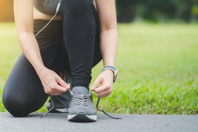 close up front view of woman's hands tying shoelaces