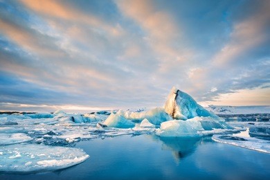 icebergs float on jokulsarlon glacier lagoon at sunrise, in iceland.