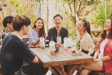 group of friends hang out in cafe play guitar and sing also use smartphone play social media