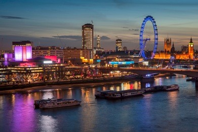 landscape image of the london skyline at night looking along the river thames