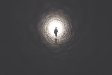 man getting out of a dark tunnel toward light