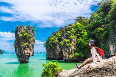 traveler asian woman in summer dress relaxing on rock joy view of james bond island, phang nga bay, near phuket, travel thailand, beautiful destination landscape asia, holiday outdoor vacation trip