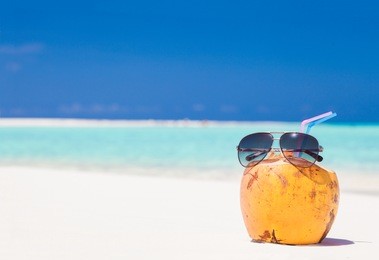 picture of fresh coconut juice and sunglasses on tropical beach