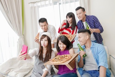 young people eat pizza and selfie happily with party