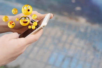 close-up of woman using smartphone sending emojis. social concept.