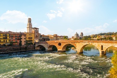 ponte pietra bridge on adige river sunny day in  verona, italy.