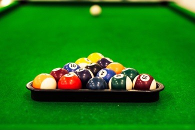 ball placed on billiards pool table with cue stick and ready for play in a recreation hall