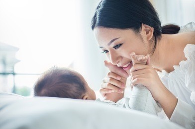 mother hands holding newborn baby feet. close up portrait of beautiful young asian mother with her newborn baby. healthcare and medical love lifestyle mother's day concept