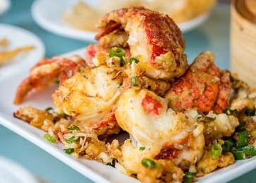 salt and pepper deep fried lobster pieces served on a plate, becoming popular in more and more overseas chinese restaurants, as a dim sum dish.