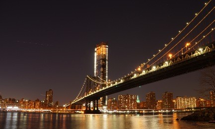 manhattan bridge at night as seen from brooklyn bridge park in new york city.