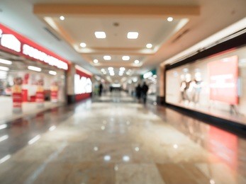 shopping mall blur background with bokeh. blurred hall of shopping mall with customers as background. copy space