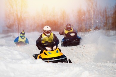 snowmobile races in snow. concept team of friends chasing mountains.