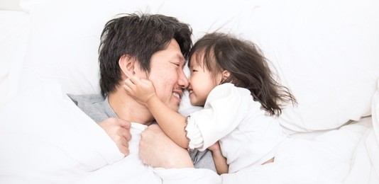 father and daughter laughing and bonding in bed. daddy and his little girl spending bed time at home. single dad fun love family lifestyle father's day concept banner