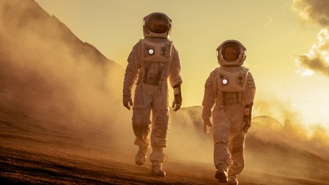 two astronauts in space suits confidently walking on mars, exploration expedition on the planet's surface. red planet covered in rocks, gas and smoke. humans overcoming difficulties.