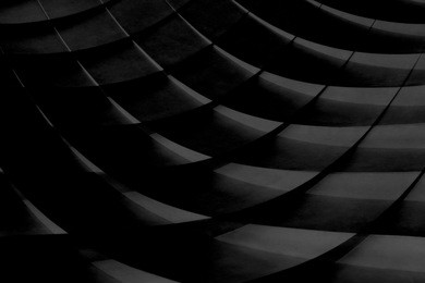 grunge close-up photo of wall panels with stair-step structure in darkness. unrecognizable modern architecture / interior fragment. abstract textured background in black and white.