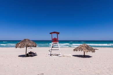varadero shoreline, umbrellas and deck chairs on the ocean shore, cuba