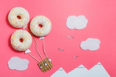 creative food minimalism, donut in shape of aerostat in pink sky with clouds, mountains, top view, copy space, travel
