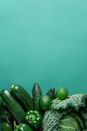 wood tray box with fresh organic green vegetables savoy cabbage zucchini cucumbers bell peppers avocados on turquoise background. superfoods vegan plant based diet concept