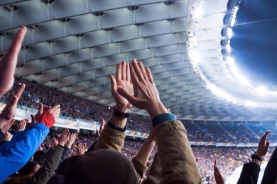 football- soccer fans support their team and celebrate goal in full stadium with open air with nice sky.-blur picture.
