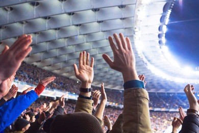 football- soccer fans support their team and celebrate goal in full stadium with open air with nice sky.-blur picture.