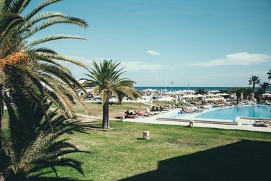 beautiful view of the pool, palms and sea from the perfect hotel in sousse, tunisia.