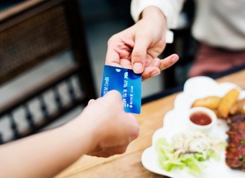 woman paying lunch with credit card at restaurant