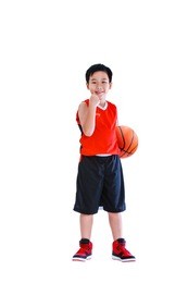 full length of winner asian child celebrating success with his hand raised.  athlete boy in sportswear smiling and looking at camera with a basketball at studio. isolated on white background.