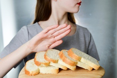 gluten intolerance concept. young girl refuses to eat white bread - shallow depth of field - selective focus on bread