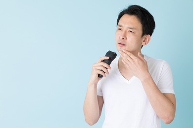 portrait of young asian man isolated on blue background