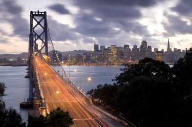 time exposure image of traffic on the bay bridge from treasure island with san francisco in the background at sunset.
