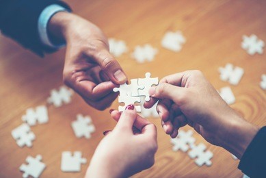 hands trying to connect couple puzzle piece with background, one part of whole. symbol of association and connection. business strategy.