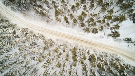 aerial view of winter road. winter landscape countryside. aerial photography of snow forest with a car on the road. captured from above with a drone. aerial photography