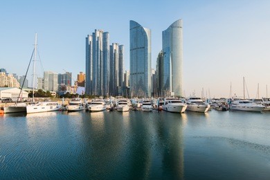 busan city skyline view at haeundae district, gwangalli beach with yacht pier at busan, south korea.