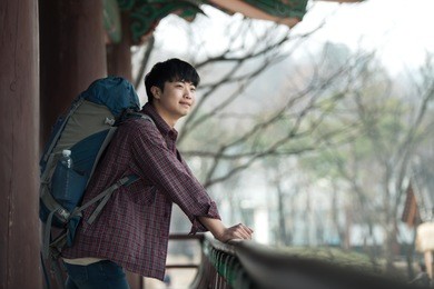a young man doing a backpacking trip in a korean traditional house.