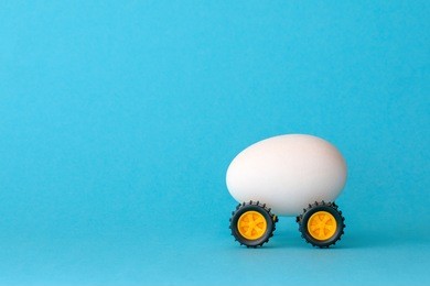 white easter egg on wheels on a blue background
