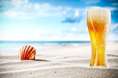 cold beer on sand and beach background 