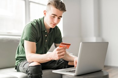 handsome man using a laptop sitting on couch at home