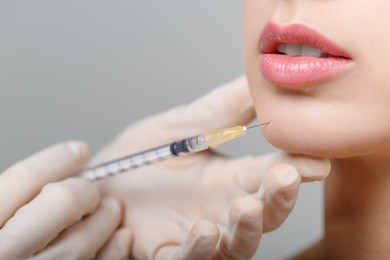 close-up portrait of young beautiful woman getting cosmetic lifting injection in lips. plastic surgery. cosmetic treatment