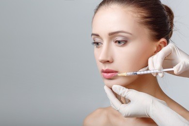 portrait of young beautiful woman getting cosmetic lifting injection in lips. plastic surgery. cosmetic treatment