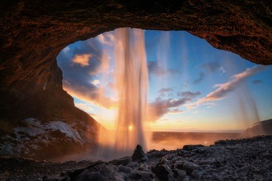 warm photo of seljalandsfoss view from inside in evening light before sunset, iceland