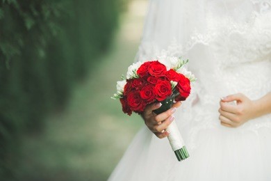 bride holding big and beautiful wedding bouquet with flowers