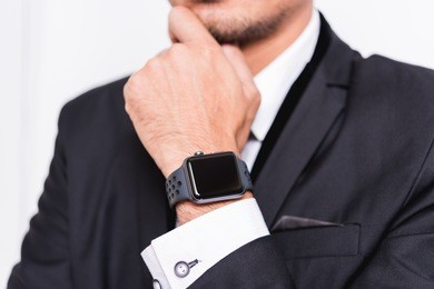 businessman wearing suit with a smart modern watch is thinking on white background