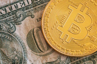 a bitcoin on us paper currency - a background of old and new.