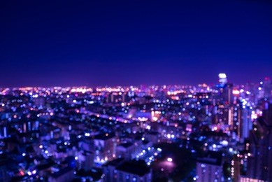 abstract urban city night light bokeh defocused background with sky space area