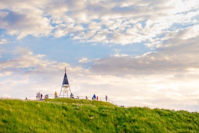 stunning scene landscape of green grass and some trees at sunset.a group of people enjoying their holiday. mt. eden, auckland, new zealand.