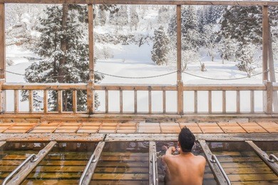 smoky outdoor onsen (hot spring) with snow in winter at a ryokan of zao hot spring, yamagata , japan 