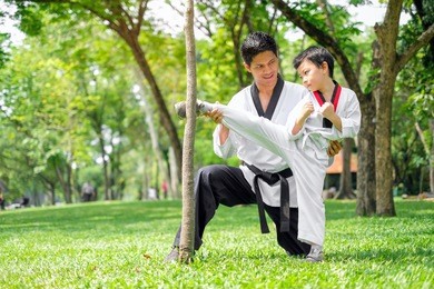 father is teacher teaching taekwondo kids, children boy are learning taekwondo in the nature park