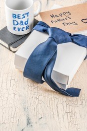 father's day gift concept, greeting card background, gift box, tie decoration, mug with inscription best dad ever, notebook, copy space